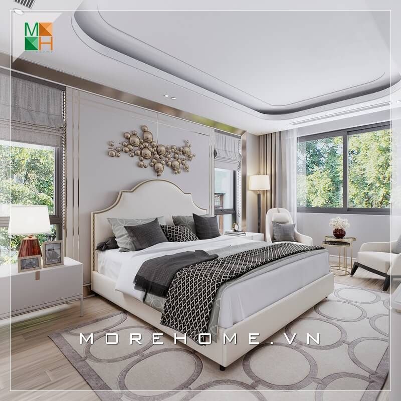 Một mẫu thiết kế phòng ngủ có nhiều cửa sổ thoáng đãng được nổi bật bởi chiếc giường tân cổ điển sắc kem sang trọng.